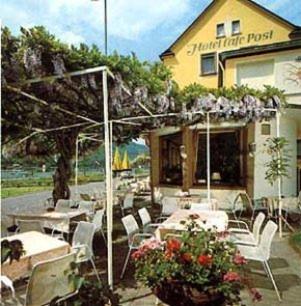 a restaurant with tables and chairs in front of a building at Hotel Café Post in Rüdesheim am Rhein