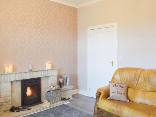 ein Wohnzimmer mit Couch und Kamin in der Unterkunft Ardlochan Cottage in Maidens