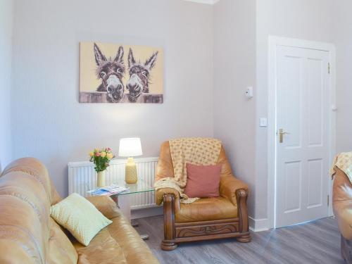 ein Wohnzimmer mit einer Couch und einem Sessel in der Unterkunft Ardlochan Cottage in Maidens