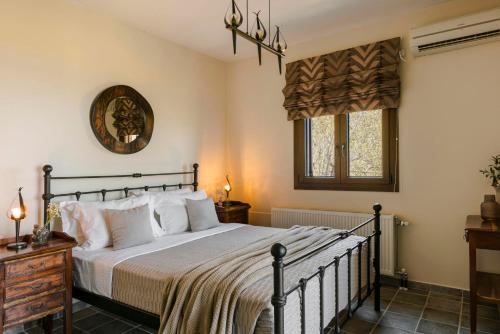 une chambre avec un grand lit et une fenêtre dans l'établissement Melanthi by Vintage Travel, à Mánganos