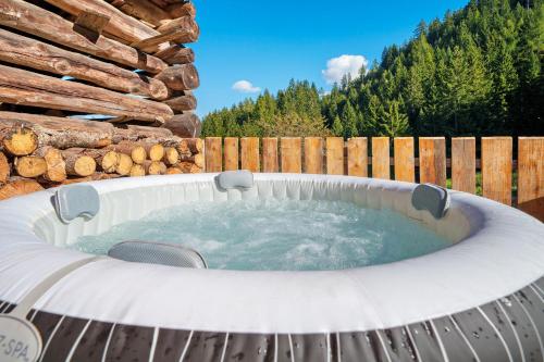 a hot tub in a backyard with a wooden fence at Gögelehof in Stulles