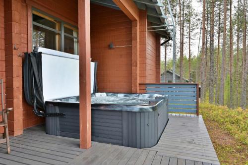 una bañera de hidromasaje en una terraza de una casa en Holiday Cabin Isomus inc outdoor jacuzzi, en Äkäslompolo