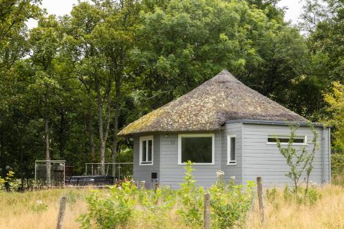 a small house with a thatched roof in a field at Ardeonaig Hotel & Restaurant in Ardeonaig