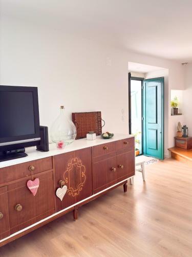 a living room with a tv and a dresser at Casa Milamores Constância in Constância