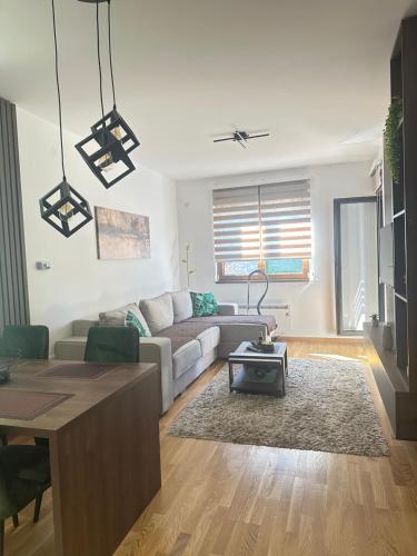 a living room with a couch and a table at Prestige apartmani Zlatibor-Prestige Forest Resort in Zlatibor