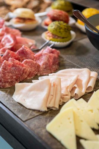 a table with different types of meats and cheese at International Hotel & Suite in San Benedetto del Tronto
