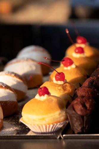 a bunch of cupcakes with cherries on top on a tray at International Hotel & Suite in San Benedetto del Tronto