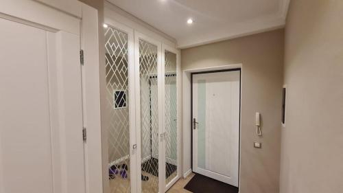 a hallway with a walk in closet with a glass door at Relaxing 2 beds Apartment, Quiet & Comfortable in Chişinău