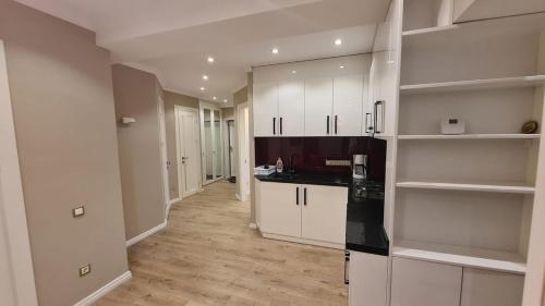 a kitchen with white cabinets and black counter tops at Relaxing 2 beds Apartment, Quiet & Comfortable in Chişinău