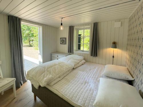 a bedroom with two beds and a window at Lovely Black Wooden House Near Tisvilde Hegn in Tisvilde
