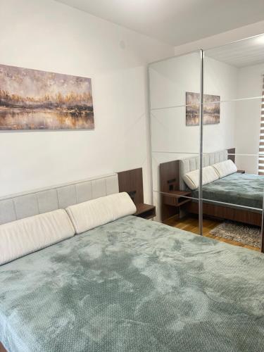 a bedroom with a large bed and a mirror at Prestige apartmani Zlatibor-Prestige Forest Resort in Zlatibor
