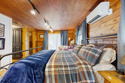 a bed in a room with a wooden ceiling at Sassafras Cottage in Waynesville