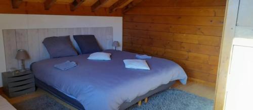 a bedroom with a large bed with two pillows at Chambres D'hôtes Barnabas in Beaune