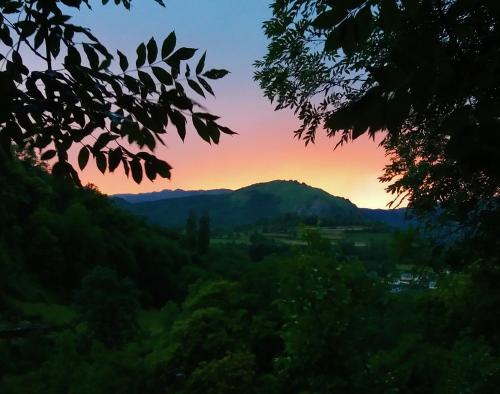 a sunset over a mountain range with trees at Les Rochers in Saint-Savin
