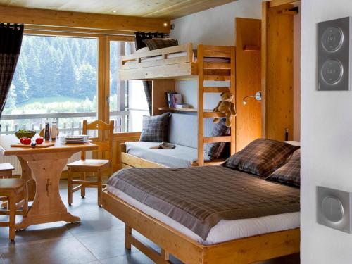 a bedroom with a bunk bed and a desk and a table at Studio Montagnard au Centre du Grand-Bornand, Proche Pistes et Bien-Être - FR-1-467-27 in Le Grand-Bornand