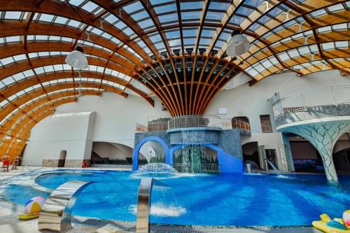 a large indoor swimming pool with a domed ceiling at Rodzinne Resorty Karkonosze in Wojcieszyce