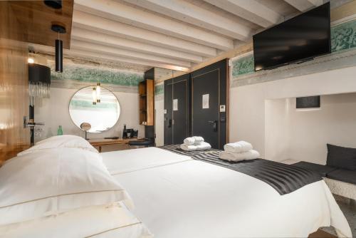 a bedroom with a large white bed with two towels at Spirito Santo Palazzo Storico - Adults Only in Rovinj