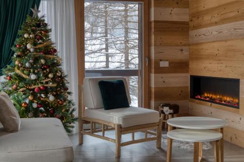 a living room with a christmas tree and a fireplace at Chalet Imbosc'chè in Livigno