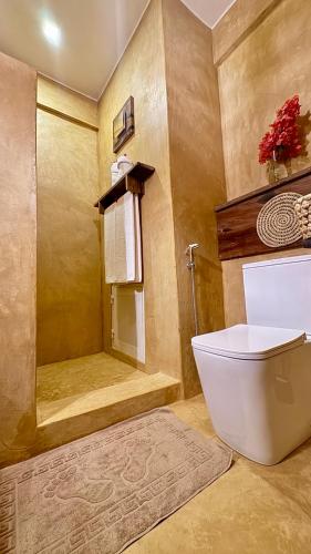 a bathroom with a toilet and a shower at Tangawizi Lodge Zanzibar - Adults Only in Jambiani