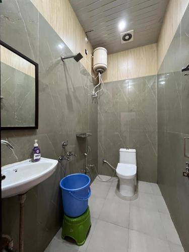 a bathroom with a sink and a toilet and a mirror at Hotel S K in Naimishāranya