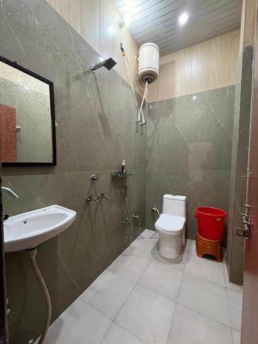 a bathroom with a sink and a toilet and a shower at Hotel S K in Naimishāranya