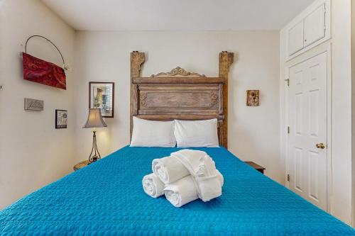 a bedroom with a blue bed with towels on it at Beachwalk Villas 23 in Folly Beach