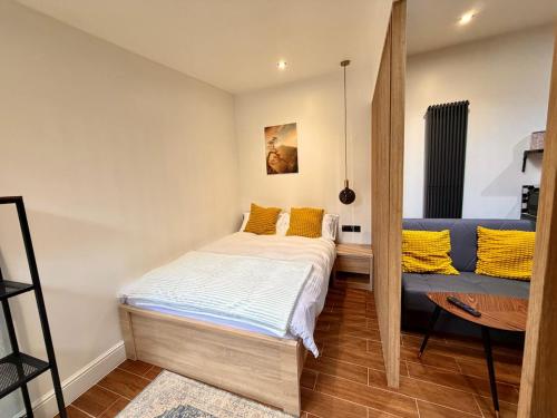 a small bedroom with a bed and a couch at The Cabin at the Orchard House- Stricly No Parties in Barton in the Clay
