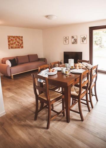 a dining room with a table and chairs and a couch at Charme e relax a 15 min da Bobbio in Viserano