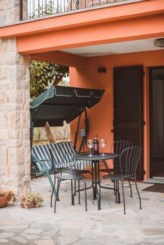 a table and chairs under an umbrella on a patio at Charme e relax a 15 min da Bobbio in Viserano