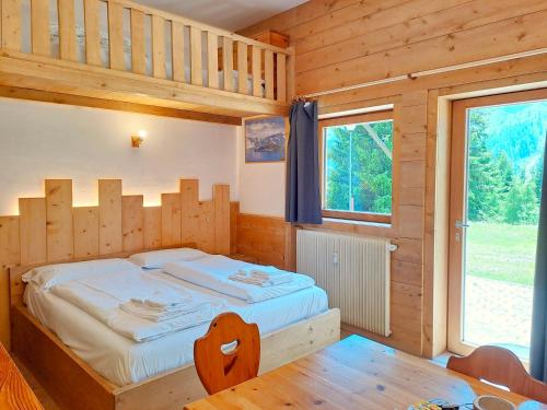 a bedroom with a bed in a wooden house at Valles Vacanze - ski in & ski out in Falcade