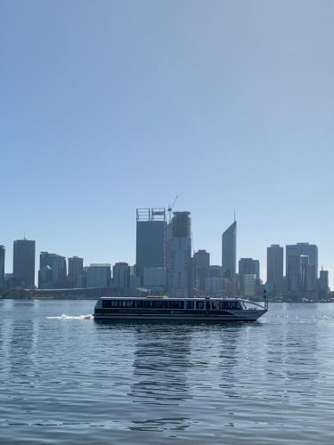 a boat on the water with a city in the background at 10/17 Richardson Street, South Perth in Perth