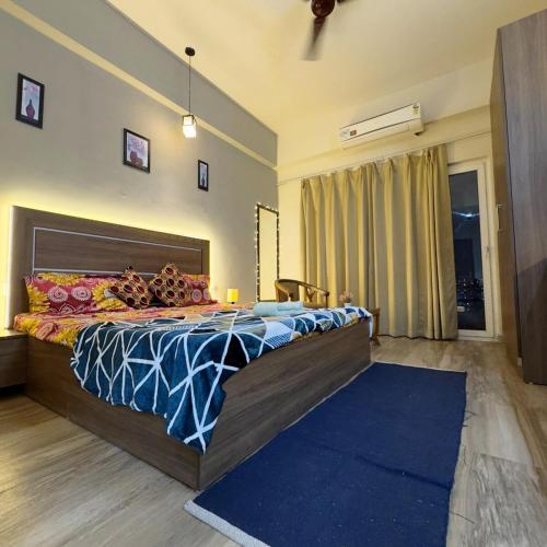 a bedroom with a large bed with a blue rug at The Chill Spot in Greater Noida