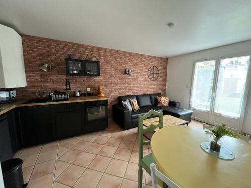 a living room with a couch and a table at Cottage en duplex meublé au calme proche Orleans in Ardon