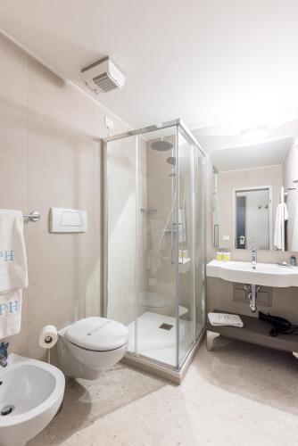 a bathroom with a shower and a toilet and a sink at Piazzi House in Sondrio