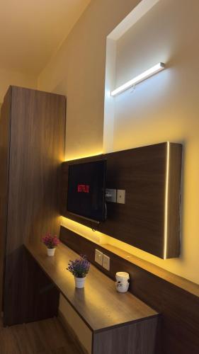 a room with a tv and a counter with flowers at The Chill Spot in Greater Noida