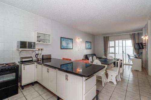 a kitchen and living room with a table and a couch at Seagull 407 in Margate