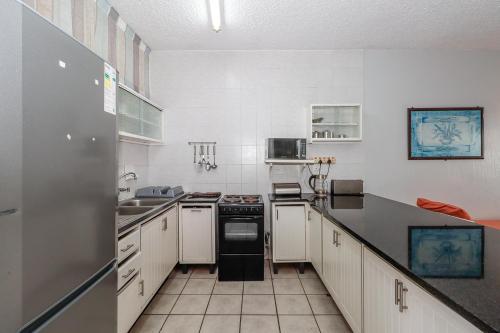a kitchen with white cabinets and a black appliance at Seagull 407 in Margate