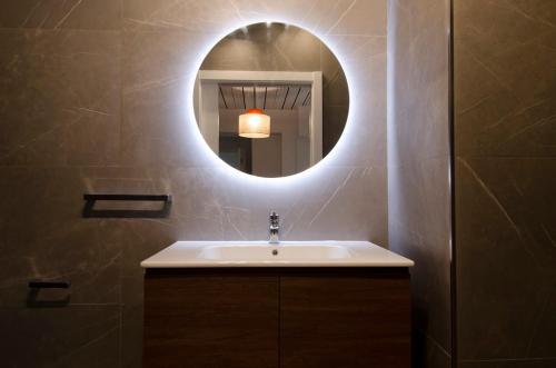 a bathroom with a sink and a mirror at Chic 2BR Apartment Steps from the Gzira Seafront in Il-Gżira