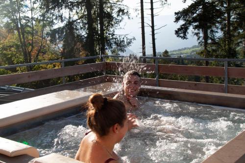 a man and a woman in a hot tub at Camping Essenza Alpina in Folgaria