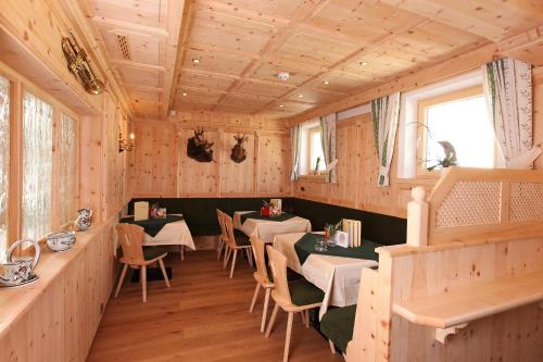 a restaurant with tables and chairs in a room at Berghotel Rasis in Galtür