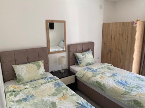 a bedroom with two beds and a mirror at Apartments and Rooms Radivojević Niš in Niš