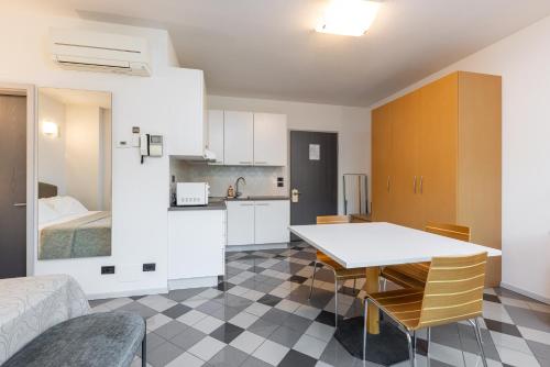 a kitchen and dining room with a table and a bed at Piazzi House in Sondrio