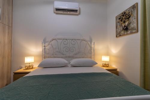 a bedroom with a bed with a green bedspread and two lamps at Modern Loutraki Apartment 3min Walk to Beach Fits 4 in Loutraki