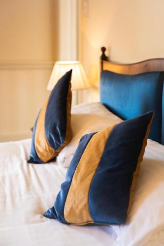 a bed with blue and gold pillows on it at Best Western Lamphey Court Hotel and Spa in Lamphey