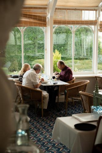 a group of people sitting at a table in a restaurant at Best Western Lamphey Court Hotel and Spa in Lamphey