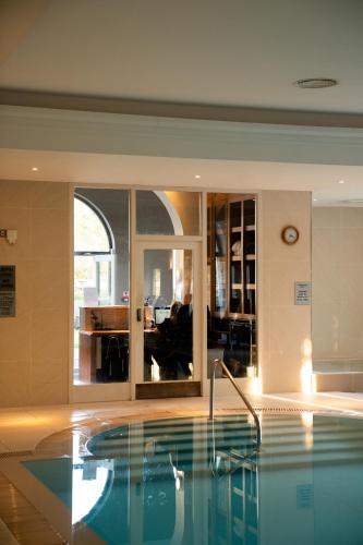 a swimming pool in a room with a living room at Best Western Lamphey Court Hotel and Spa in Lamphey