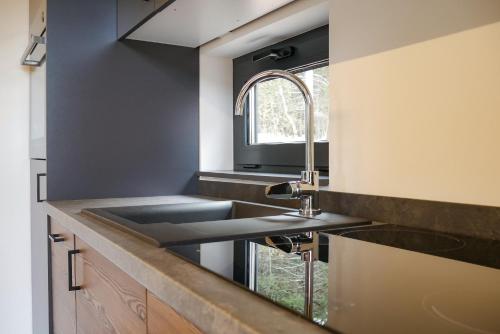a kitchen with a sink and a window at Camping Essenza Alpina in Folgaria