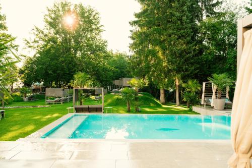 a swimming pool in a yard with trees at Das Parkhotel in Bad Wörishofen