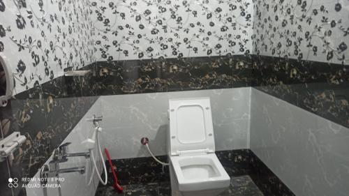a bathroom with a white toilet in a wall at Munnar Wood valley in Munnar