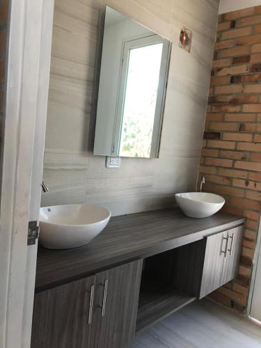 a bathroom with two sinks and a mirror at Hermosa cabaña cerca Restrepo in Villavicencio